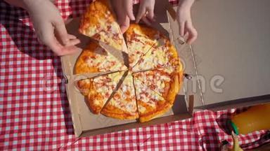 一家人打开一个纸板披萨盒，然后<strong>双手拿</strong>着令人垂涎的披萨